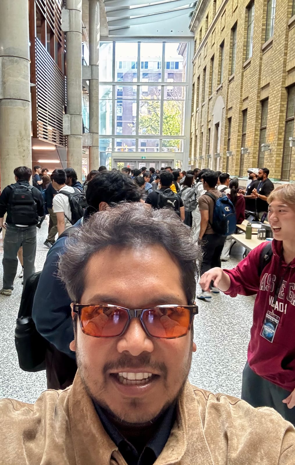 Selfie in the Bahen Centre atrium with the check-in crowd behind.