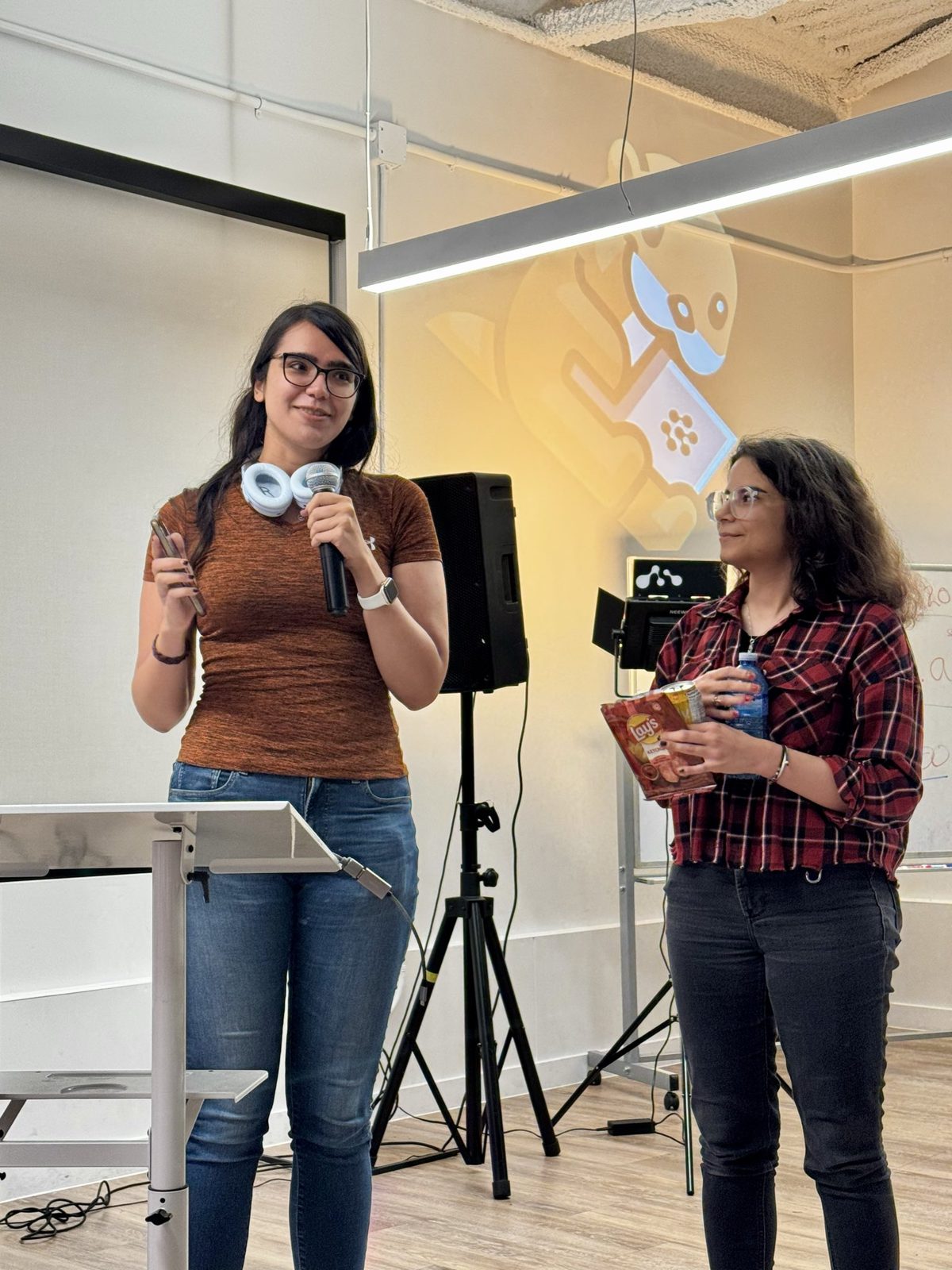Two hosts at the microphone in front of the room at devkick Kick 003