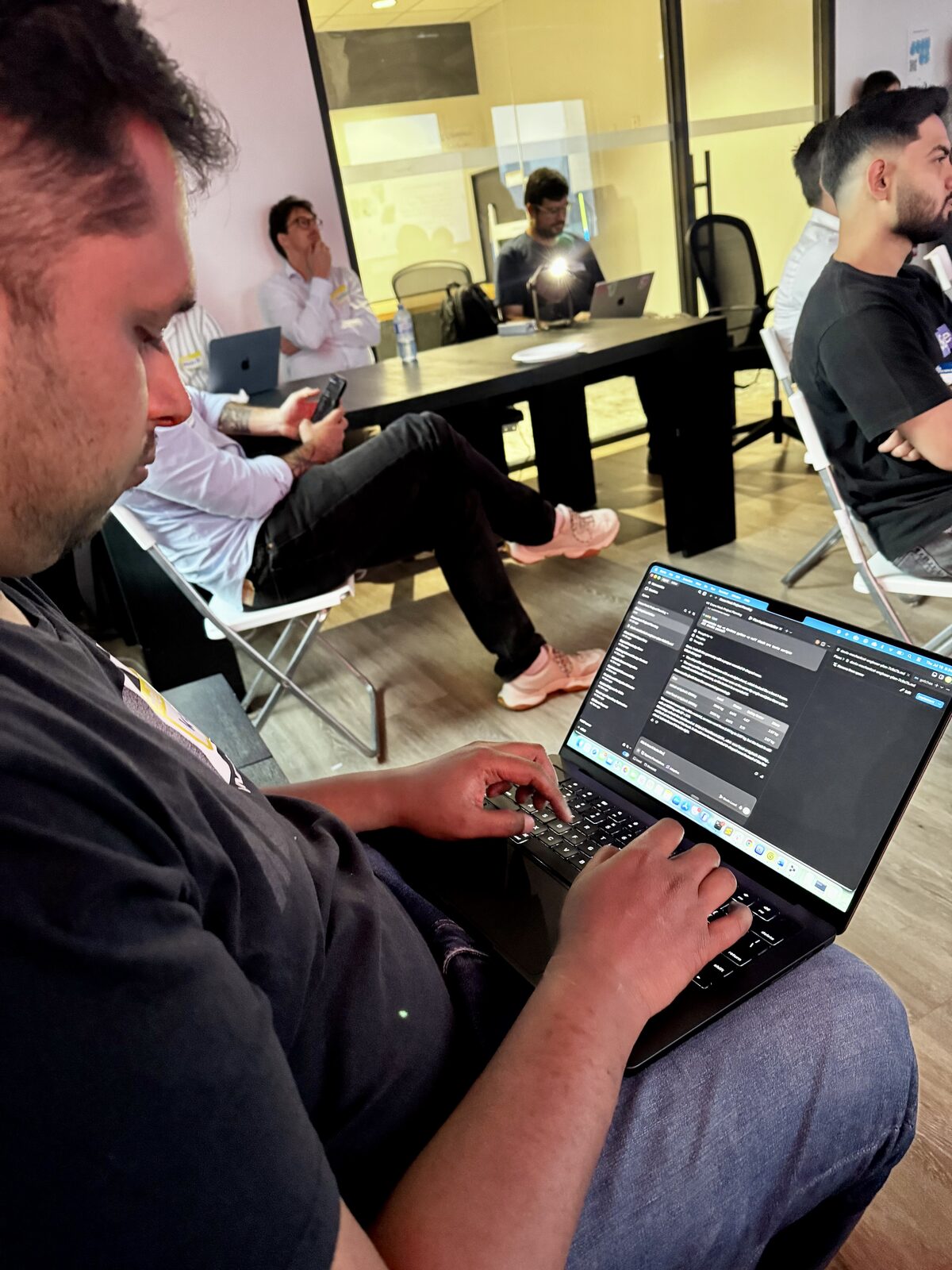 A builder coding on a laptop during the build night
